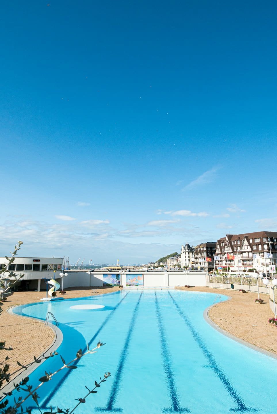 Piscina esterna con acqua azzurra brillante in una giornata di sole.